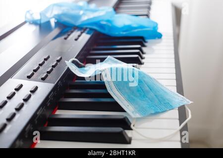 Auf dem Klavier liegen Virenschutzmaske und Handschuhe Stockfoto