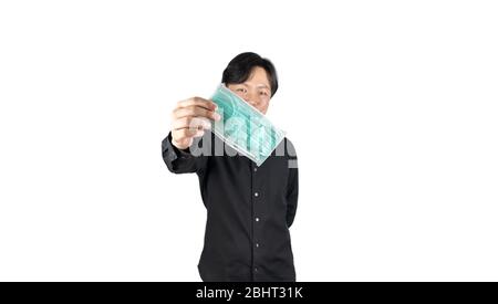 Asiatischer Mittelmann in einem schwarzen Hemd, trägt eine grüne Hygienemaske und kreuzt die Rückseite des Armes, steht vor einem weißen klaren Hintergrund. Stockfoto