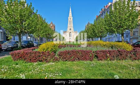 Brüssel, Belgien - 26. April 2020: Louis Bertrand Avenue und seine renovierte Kirche in Schaerbeek ohne Menschen während der Haftzeit. Stockfoto