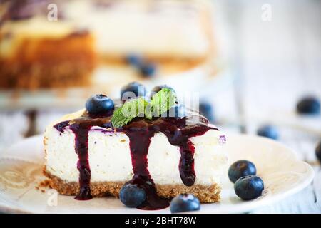 Ein Stück köstlicher hausgemachter Heidelbeer-Marmortheke mit graham Cracker Crust, Heidelbeersauce und frischen Heidelbeeren. Selektiver Fokus mit Extre Stockfoto