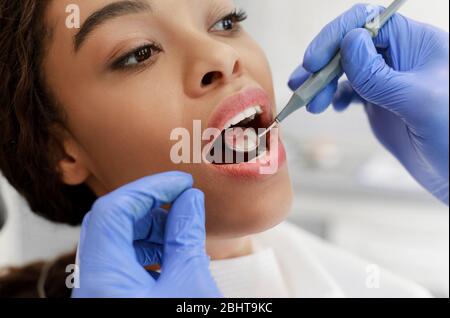 Cropped von Zahnarzt Überprüfung schwarze Frau für Karies Stockfoto