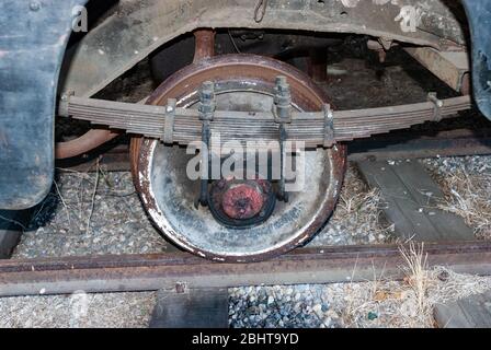 Altes Eisenbahnrad mit Federn für Abschreibung. Eisenbahnrad vom Auto auf der Schmalspurbahn. Stockfoto