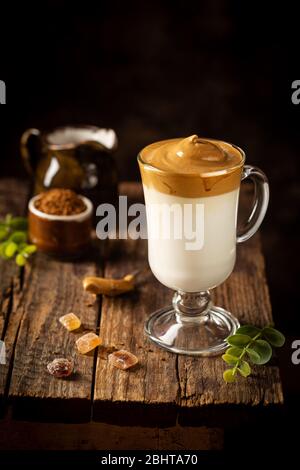 Dalgona Coffee, ein kühler, flauschiger, geschlagene Kaffee in einem Glas. Latte Espresso mit Kaffeeschaum in hohem Glas. Trendiges Getränk Stockfoto