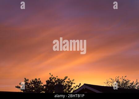 Ein wunderschöner Sonnenuntergang im Frühling, der im April mit Orange-, Violett- und Blautönen eingefangen wurde Stockfoto