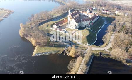 Blick von der Drohne auf beeindruckende mittelalterliche Palast und Park Ensemble von Teichen in der weißrussischen Stadt Nyasvizh am Wintertag umgeben Stockfoto