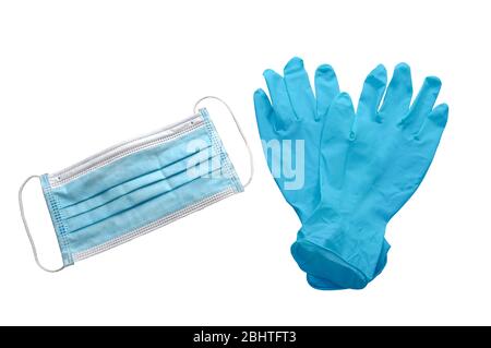 Horizontale Aufnahme einer schützenden Gesichtsmaske, die neben einem Paar gekreuzte blaue Gummihandschuhe auf weiß isoliert liegt. Stockfoto