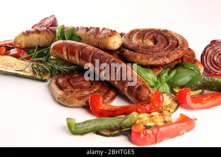 Verschiedene köstliche gegrilltes Fleisch mit Gemüse auf einem Grill mit gegrillten Würstchen und Gemüse. Hintergrund und Würstchen Stockfoto