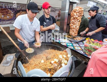 Samara, Russland - 5. Oktober 2019: Kochen appetitlich traditionellen orientalischen Pilaf in einem großen Kessel im Freien während der ethnischen Urlaub Stockfoto