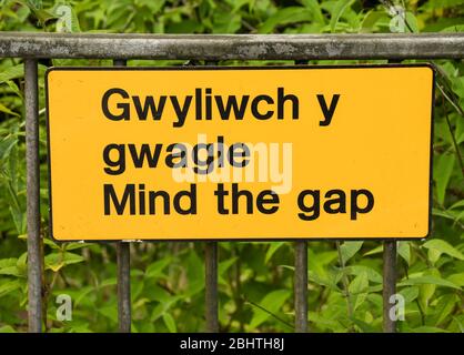 Nahaufnahme eines zweisprachigen Schilds "Mind the Gap" auf einem Bahnsteig Stockfoto