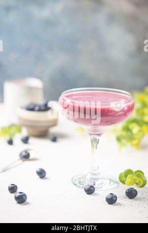 Hausgemachte antioxidative Sommer Heidelbeer Smoothie in einem Glas auf weißem Tisch Stockfoto