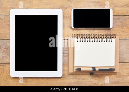 Arbeitsplatz Smartphone, Papier, Tablet auf Holzhintergrund. Draufsicht. Stockfoto