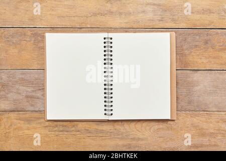 Notizblock oder Notizbuch mit auf braunem Holztischhintergrund. Draufsicht. Stockfoto