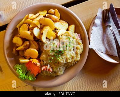 Traditionelles polnisches Eintopf mit Schweinefleisch und Sauerkraut mit Beilage aus gebackenen Kartoffeln Stockfoto