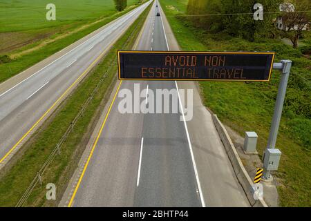 Erhöhte Ansicht eines elektronischen Nachrichtenbretts über dem Trans-Canada Highway rät Menschen, nicht unbedingt reisen zu müssen, zu Hause bleiben! Stockfoto