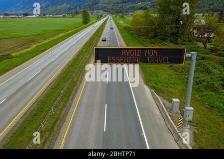 Erhöhte Ansicht eines elektronischen Nachrichtenbretts über dem Trans-Canada Highway rät Menschen, nicht unbedingt reisen zu müssen, zu Hause bleiben! Stockfoto