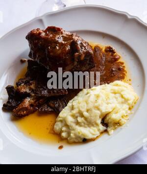 Köstliche geschmorte in Ofen Lammfleisch mit Soße serviert mit gebratenen Pilzen und Kartoffelpüree Stockfoto