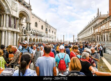 Die sichtbaren Auswirkungen des Übertourismus, da Kreuzfahrtschiffpassagiere an einem geschäftigen Tag in Venedig den Gang am Dogenpalast auf dem Markusplatz drängen Stockfoto