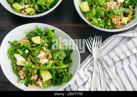 Zitronen-Arugula-Salat mit Couscous, Gurken und Feta: Rucula-Salat mit Gurkenstückchen, Feta-Käsebröseln und Vollkorn-Perlmutt-Couscous Stockfoto