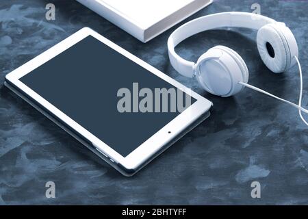 Papierbuch, eBook und Hörbuchformat auf einem schwarzen Holztisch. Top-Down-Ansicht eines Desktops mit leerem Kopierspeicher für den Inhalt des Editors. Stockfoto