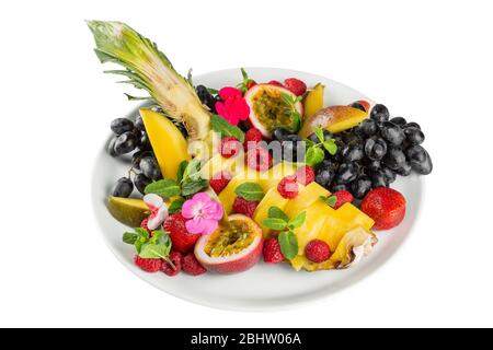 Verschiedene frische Früchte auf einem Teller. Banane, Erdbeeren, Himbeeren, Ananas. Stockfoto