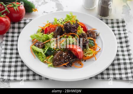 Salat aus frischem Gemüse, Hühnerleber und koreanischen Karotten. Stockfoto