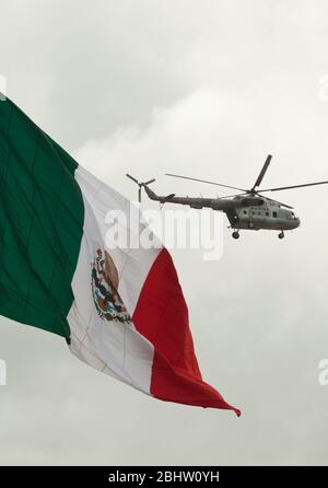 Brownsville, Texas, USA, September 2010: Ein Militärhubschrauber der mexikanischen Marine patrouilliert am Rio Grande River vorbei an einer großen mexikanischen Flagge an der US-Grenze zu Brownsville, Texas, am Freitagnachmittag nach Berichten über mehrere Schießereien zwischen Drogenkartellen und staatlichen Sicherheitskräften in Matamoros. Mehr als zwei Dutzend wurden bei den Vorfällen getötet. ©Bob Daemmrich Stockfoto