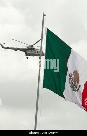 Brownsville, Texas, USA, September 2010: Ein Militärhubschrauber der mexikanischen Marine patrouilliert am Rio Grande River vorbei an einer großen mexikanischen Flagge an der US-Grenze zu Brownsville, Texas, am Freitagnachmittag nach Berichten über mehrere Schießereien zwischen Drogenkartellen und staatlichen Sicherheitskräften in Matamoros. Mehr als zwei Dutzend wurden bei den Vorfällen getötet. ©Bob Daemmrich Stockfoto