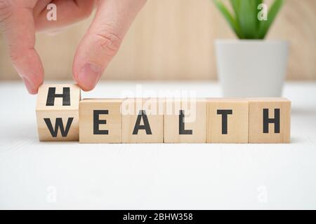 Konzept Gesundheit Reichtum auf Holzblock halten Hand. Nahaufnahme. Stockfoto