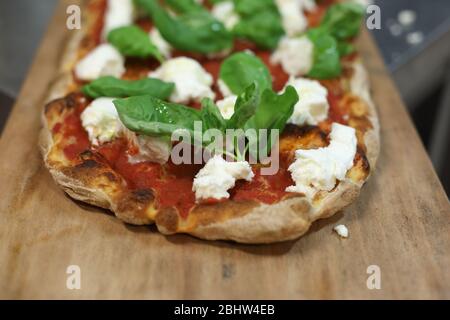 Flache Pizza mit Mozzarella, Tomatensauce und Basilikum in Italien Stockfoto