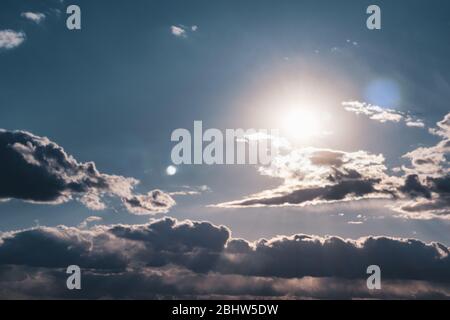 Landschaftlich schöne Abendsonne in Wolken am blauen Himmel. Sonnenlicht in hohen großen dramatischen Wolkenlandschaft stimmungsvollen Hintergrund Stockfoto