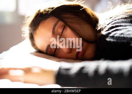 Frau schläft in einem weißen Bett am Morgen. Konzept des Schlafes und guten Morgen. Stockfoto