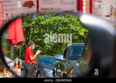 Chick-fil-A Mitarbeiter, der die Sicherheitsrichtlinien von COVID-19 beachtet, während er Drive-Thru-Bestellungen in einem Chick-fil-A Restaurant in Metro Atlanta, Georgia, entgegennimmt. (USA) Stockfoto