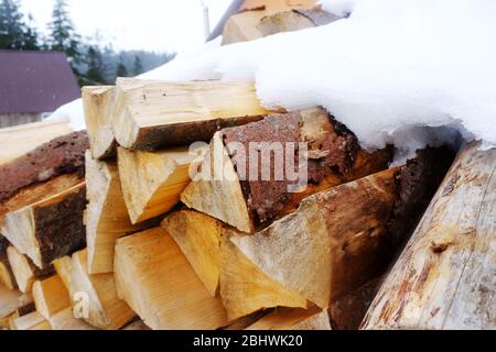 Brennholz im Schnee draußen, Nahaufnahme Stockfoto