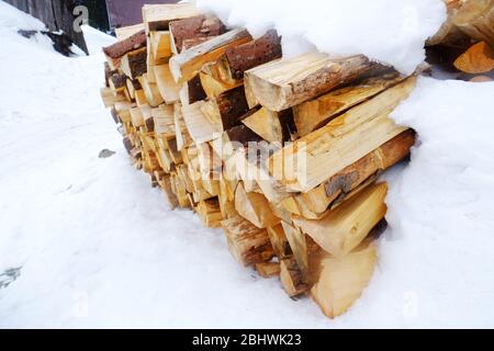 Brennholz im Schnee draußen, Nahaufnahme Stockfoto