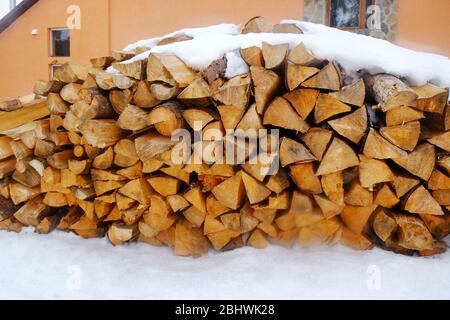 Brennholz im Schnee draußen, Nahaufnahme Stockfoto