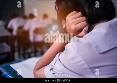 Schüler denken und nehmen Prüfungsantwort im Klassenzimmer mit Stress Stockfoto