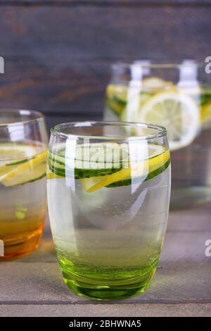 Frisches Wasser mit Zitrone und Gurke in Glaswaren auf Holzhintergrund Stockfoto