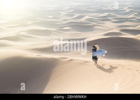 Einsame freie Frau inmitten einer verlassenen Wüste. Rennt in die Freiheit, um seinem Traum zu entsprechen. Stockfoto