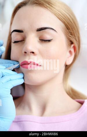 Kosmetikerin, die permanent Make-up auf die Lippen anwendet Stockfoto