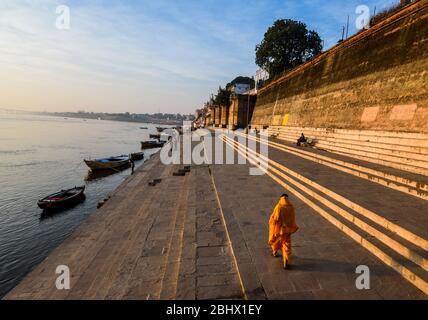 Mann, der auf dem Ghat der heiligen Stadt Varanasi, Uttar Pradesh, Indien geht. Stockfoto