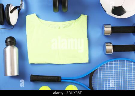 Sportausrüstung und T-Shirt auf Farbtisch, Draufsicht Stockfoto