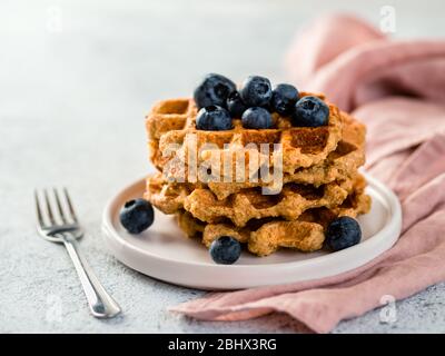 Einfache gesunde glutenfreie Haferwaffeln mit Kopierplatz. Stapel von appetitlichen hausgemachten Waffeln mit Hafermehl verziert Heidelbeeren, auf Teller über hellgrauen Zement Hintergrund Stockfoto
