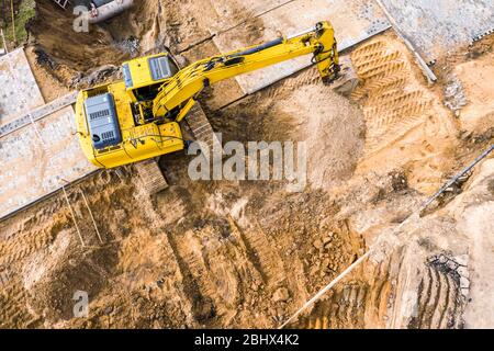 Gelbe Bagger auf einer Baustelle. Luftaufnahme von fliegender Drohne Stockfoto