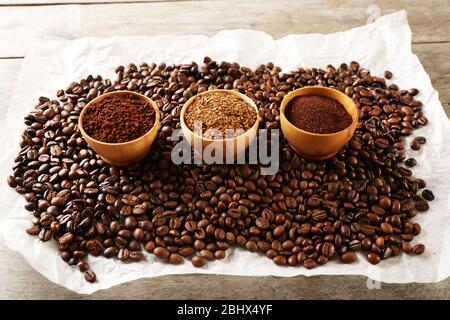 Kaffeebohnen auf zerknittert Pergament auf Holztisch, Nahaufnahme Stockfoto