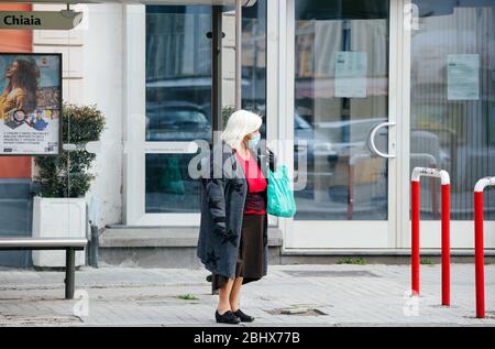 Neapel, Italien. April 2020. Eine Frau, die als vorbeugende Maßnahme eine Gesichtsmaske trägt und während der Sperrung auf einen Bus wartet.nach der COVid19-Pandemie, die Italien stark getroffen hat, hat der Premierminister Giuseppe Conte strenge Beschränkungen für die Quarantäne angeordnet, um die Ausbreitung des Corona-Virus zu minimieren. Quelle: SOPA Images Limited/Alamy Live News Stockfoto