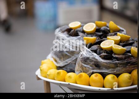 Gefüllte Muscheln auf der Straße. Traditionelle mediterrane Vorspeise. Neben den Muscheln gibt es Zitronen. Nahaufnahme. Stockfoto