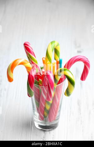 Bunte Candy Stöcke in Glas auf Holzhintergrund Stockfoto