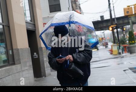 New York City, USA. April 2020. Ein Mann mit Regenschirm geht inmitten des Coronavirus-Ausbruchs auf einer leeren Straße in Brooklyn.Da die USA 50,000 bestätigte Todesfälle durch Coronavirus übertreffen, deuten die Antikörpertests des Staates New York darauf hin, dass 14.9% der New yorker Covid-19 positiv bewerten. Quelle: Braulio Jatar/SOPA Images/ZUMA Wire/Alamy Live News Stockfoto