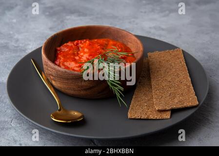 Ajvar, Lutenitsa, Pinjur, Harissa mit Brot auf einem Teller. Nahaufnahme Stockfoto