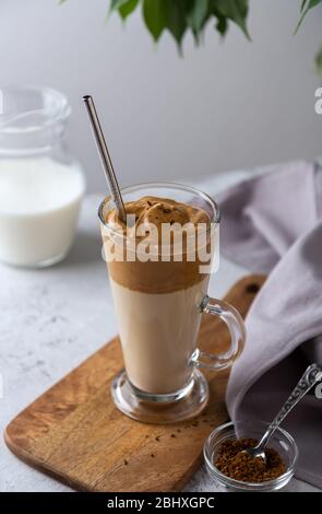 Kalter Dalgon Kaffee, ein koreanisches Getränk mit Schlagkaffee und Milch in einem Glasglas auf hellem Hintergrund Stockfoto